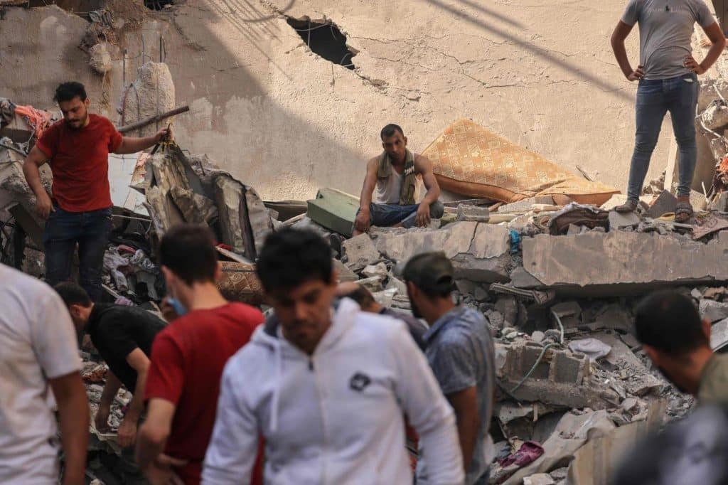 Un hombre se encuentra entre los restos de un edificio impactado por un misil israelí, mientras la comunidad palestina busca sobrevivientes en Jan Yunis, al sur de la Franja de Gaza. (Mahmud Hams)