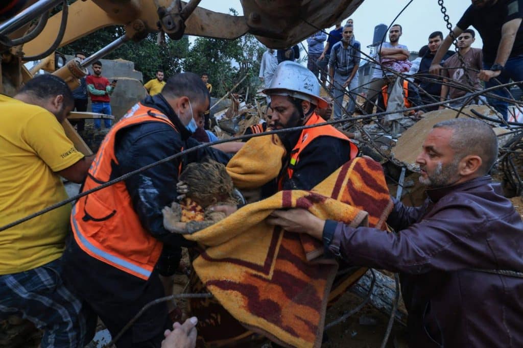 Rescate de una persona herida entre los escombros de un edificio dañado por los ataques israelíes en Jan Yuris. (Mahmud Hams)