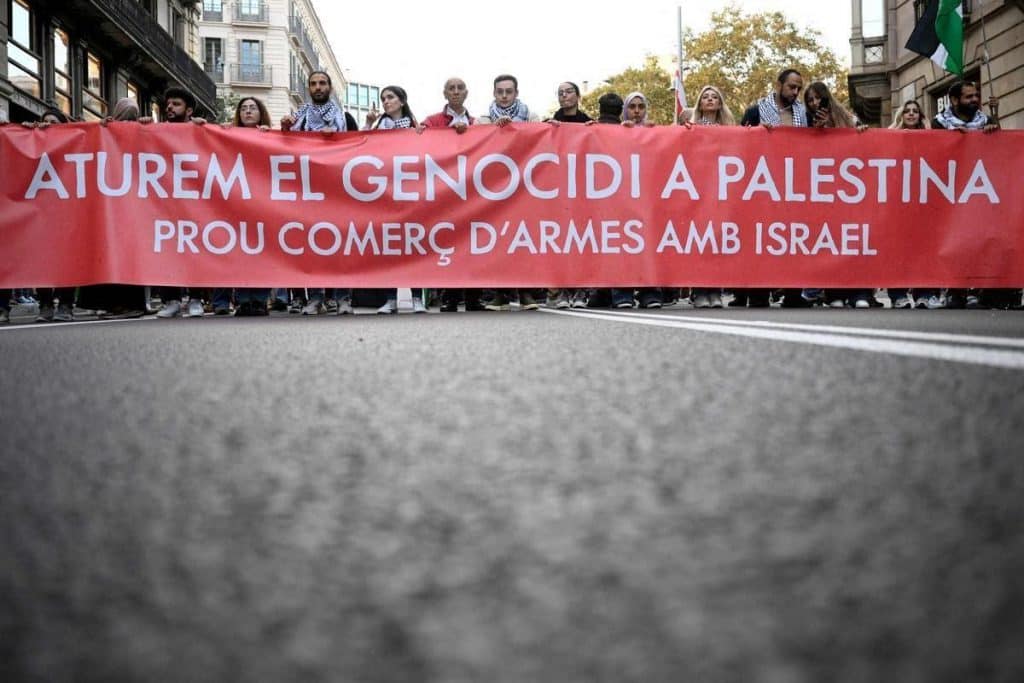 “Detengan el genocidio en Palestina. Basta al comercio de armas con Israel”, rezan las pancartas en catalán en la marcha de Barcelona, donde han asistido unas 30,000 personas. (EFE)