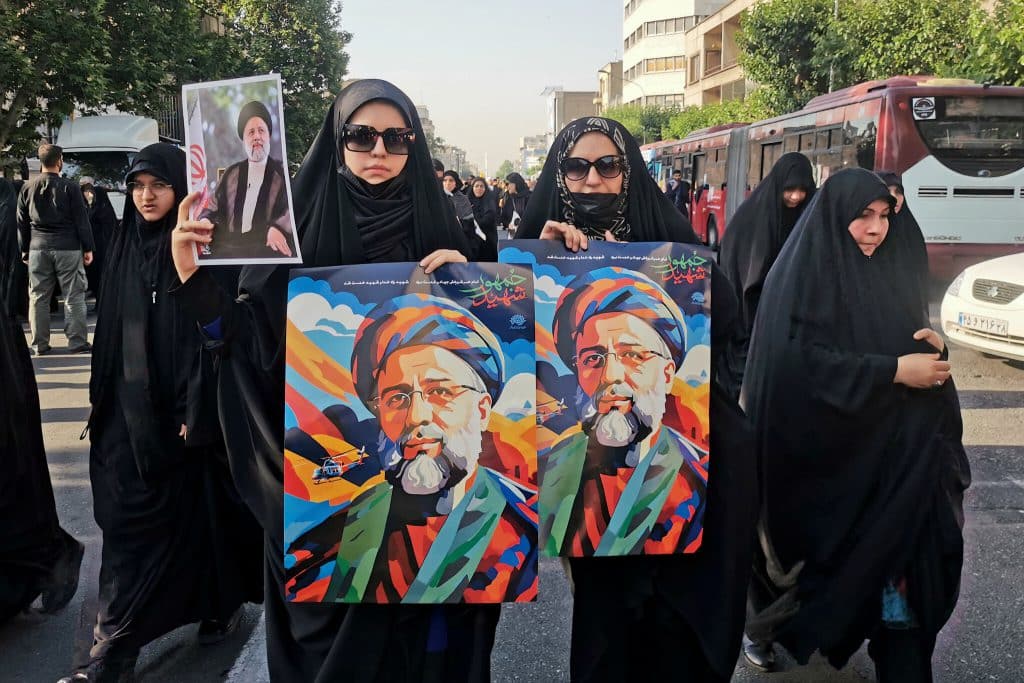 Los asistentes de la ceremonia fúnebre sostienen pancartas del presidente iraní Ebrahim Raisí durante una ceremonia fúnebre en Teherán en honor a él y a sus acompañantes fallecidos en un accidente de helicóptero.