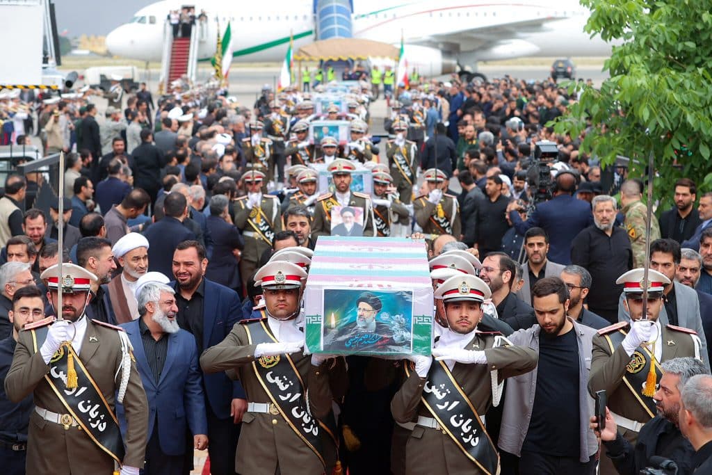 Los guardias de honor llevan los féretros del fallecido presidente de Irán, Ebrahim Raisi, del ministro de Relaciones Exteriores Hossein Amir-Abdollahian y de otros durante una procesión fúnebre en el Aeropuerto de Mehrabbad en Teherán.