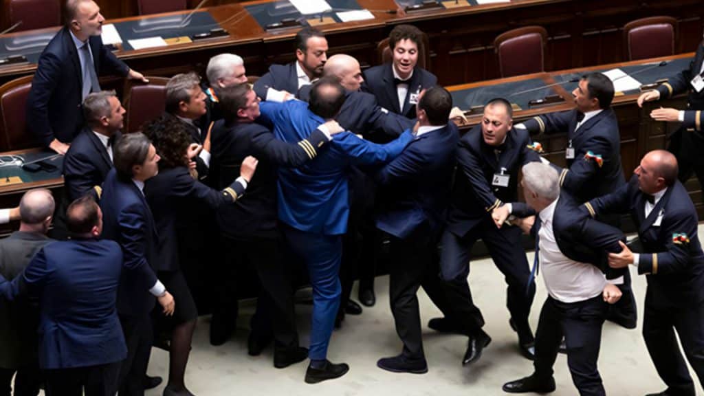 Evacuación de congresista italiano tras violenta pelea en la Cámara de Diputados.