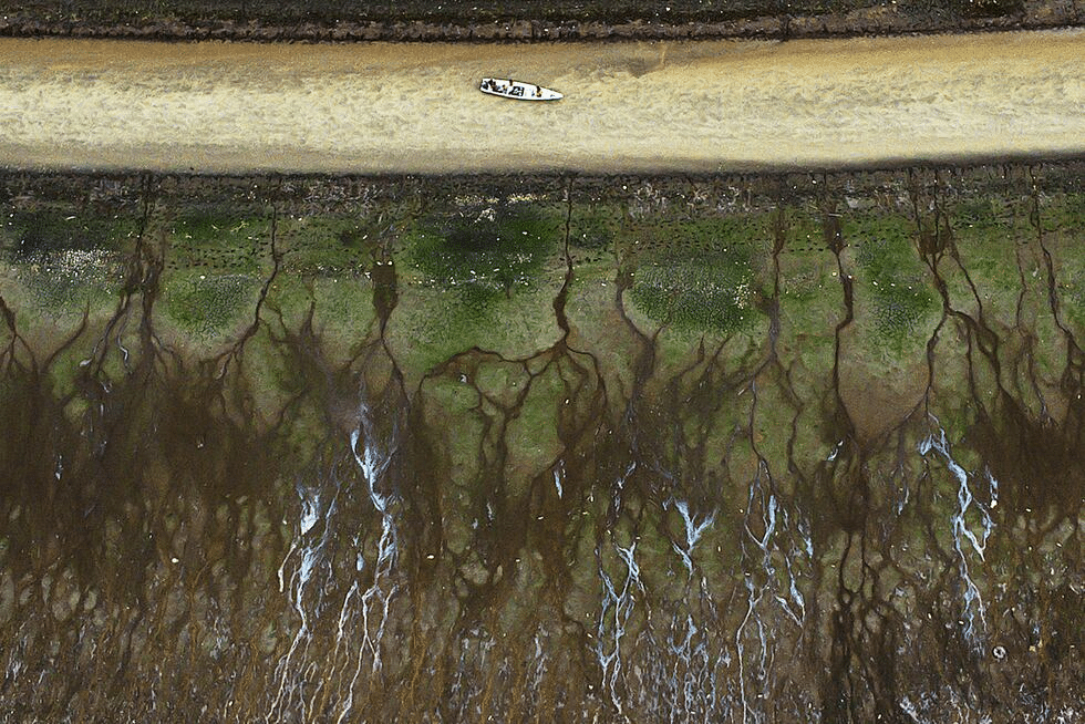 En la imagen, una embarcación cruza lo que resta de las aguas en el lago do Aleixo, ante la sequía de la Amazonía brasileña el 25 de octubre de 2022. RAPHAEL ALVES (EFE)