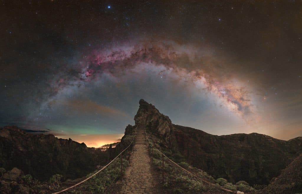 "Madeira y la Vía Láctea". Capturada el 15 de abril, la impresionante imagen revela un sendero angosto y pedregoso que conduce a una cresta rocosa en una isla portuguesa. En el fondo, el cielo despliega una gama de colores fascinantes: una rica capa de nubes doradas se transforma en cielos verdes espectaculares antes de desvanecerse en tonos más profundos y oscuros.