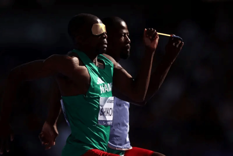 Ananias Shikongo de Namibia, junto a su guía, participó en la prueba de 100 metros planos.