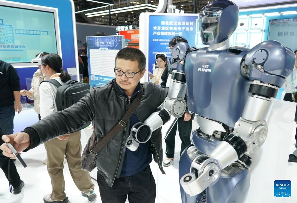 Visitante fotografiándose con un robot en la Exposición Internacional de Cadenas de Suministro en Beijing.