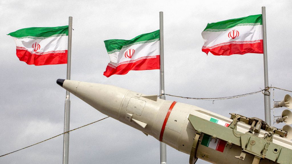 Misil balístico iraní exhibido junto a las banderas oficiales de Irán durante un evento militar en Teherán