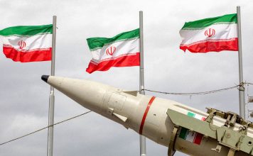 Irán lanza dura advertencia a Estados del Golfo por apoyo a EEUU Misil balístico iraní exhibido junto a las banderas oficiales de Irán durante un evento militar en Teherán