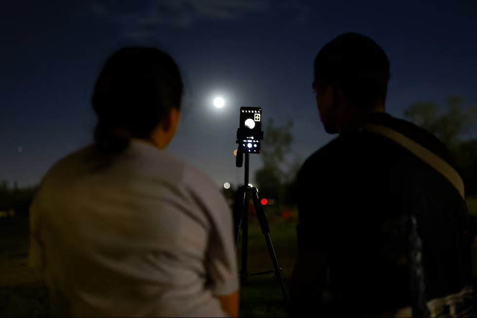 Una pareja observa el eclipse, en el parque El Chamizal, Ciudad Juarez, Chihuahua, México