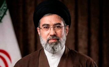 Ayatolá Jameneí: El camino del progreso de Irán jamás será la sumisión a Estados Unidos El ayatolá Seyed Mojtaba Jameneí, líder de la Revolución Islámica de Irán, frente a la bandera iraní.
