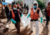 Gaza recupera 233 cuerpos bajo escombros tras bombardeos israelíes Personal de defensa civil traslada un cuerpo entre los escombros en Gaza.
