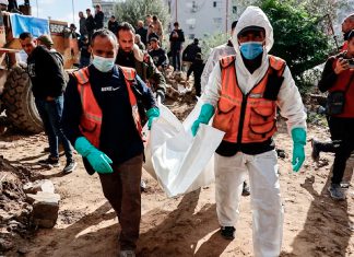 Gaza recupera 233 cuerpos bajo escombros tras bombardeos israelíes Personal de defensa civil traslada un cuerpo entre los escombros en Gaza.