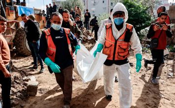 Gaza recupera 233 cuerpos bajo escombros tras bombardeos israelíes Personal de defensa civil traslada un cuerpo entre los escombros en Gaza.