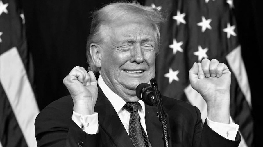 Donald Trump habla frente a banderas de Estados Unidos durante un acto público.
