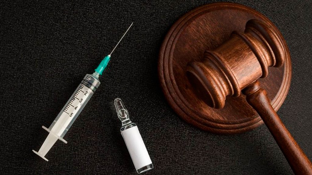 Jeringa y medicamento junto a un mazo judicial en el debate sobre eutanasia en Francia