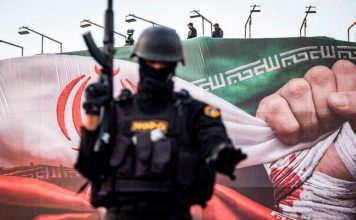 Irán advierte a Estados Unidos: Una nueva agresión tendrá una respuesta histórica Fuerzas especiales de la policía de Irán vigilan una zona de Teherán frente a una bandera iraní.