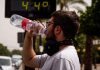 España registra en 2026 su mayor mortalidad por calor Hombre bebe agua mientras un termómetro marca 44 grados.