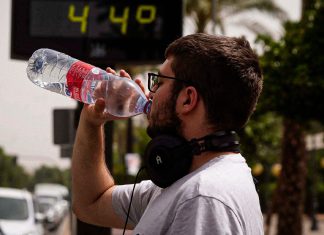 España registra en 2026 su mayor mortalidad por calor Hombre bebe agua mientras un termómetro marca 44 grados.