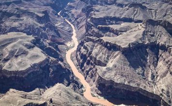Inundaciones golpean el Gran Cañón dejando fallecidos y desaparecidos Vista aérea del Gran Cañón con aguas turbias tras inundaciones.