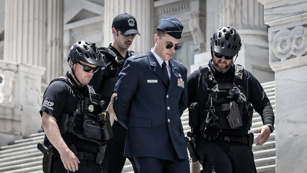 Agentes de seguridad escoltan a Jason Watson durante su detención en el Capitolio.