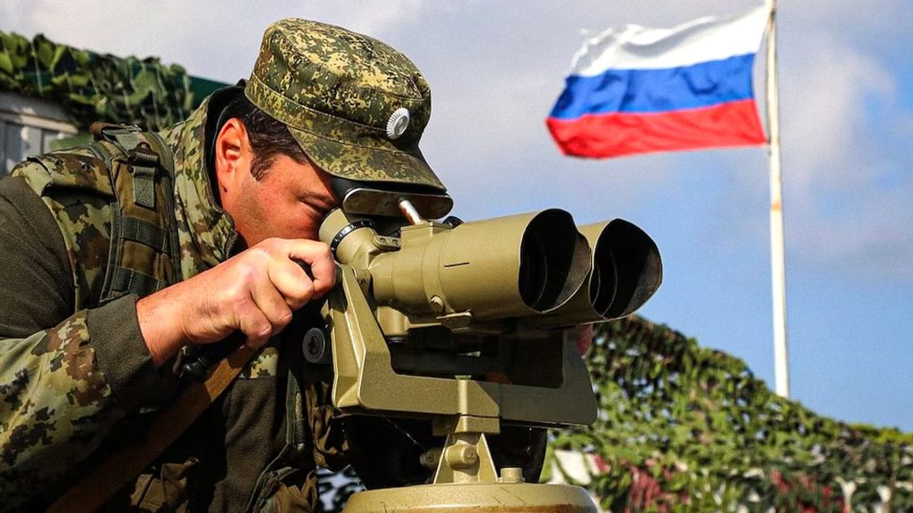 Militar ruso desplegado en Crimea observa con binoculares desde una posición de comando.