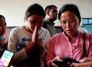 Quiénes son los turistas extranjeros desaparecidos tras la tragedia en Nepal y China Peregrinas esperan información en el Himalaya tras un desastre mientras revisan sus teléfonos.