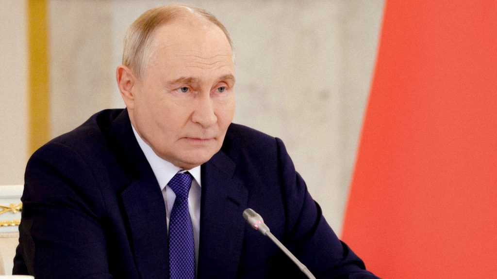 Vladímir Putin durante una reunión oficial con la bandera de Rusia al fondo