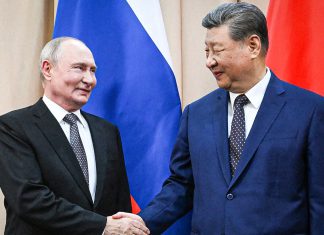 Organización de Shanghái reúne a líderes de Eurasia en Kirguistán Vladímir Putin y Xi Jinping se estrechan la mano frente a las banderas de Rusia y China.