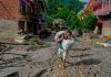 Aumenta la cifra de fallecidos y desaparecidos por devastadora avalancha en Nepal y China Mujer camina entre lodo y escombros tras inundaciones en Nepal mientras continúan las labores de rescate.