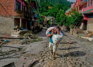 Aumenta la cifra de fallecidos y desaparecidos por devastadora avalancha en Nepal y China Mujer camina entre lodo y escombros tras inundaciones en Nepal mientras continúan las labores de rescate.
