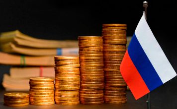 Rusia se consolida como cuarta economía mundial pese a sanciones Monedas y bandera de Rusia representan el crecimiento de su economía pese a las sanciones.