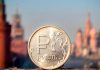 Rusia activa su nueva moneda digital Moneda de rublo ruso frente a edificios de una ciudad de Rusia