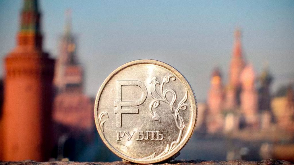 Moneda de rublo ruso frente a edificios de una ciudad de Rusia