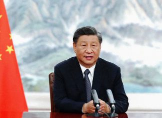 China rechaza nuevas sanciones de Donald Trump contra Irán La fotografía muestra a Xi Jinping, presidente de China, sentado frente a dos micrófonos y junto a la bandera china.