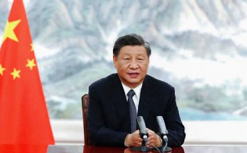 China rechaza nuevas sanciones de Donald Trump contra Irán La fotografía muestra a Xi Jinping, presidente de China, sentado frente a dos micrófonos y junto a la bandera china.