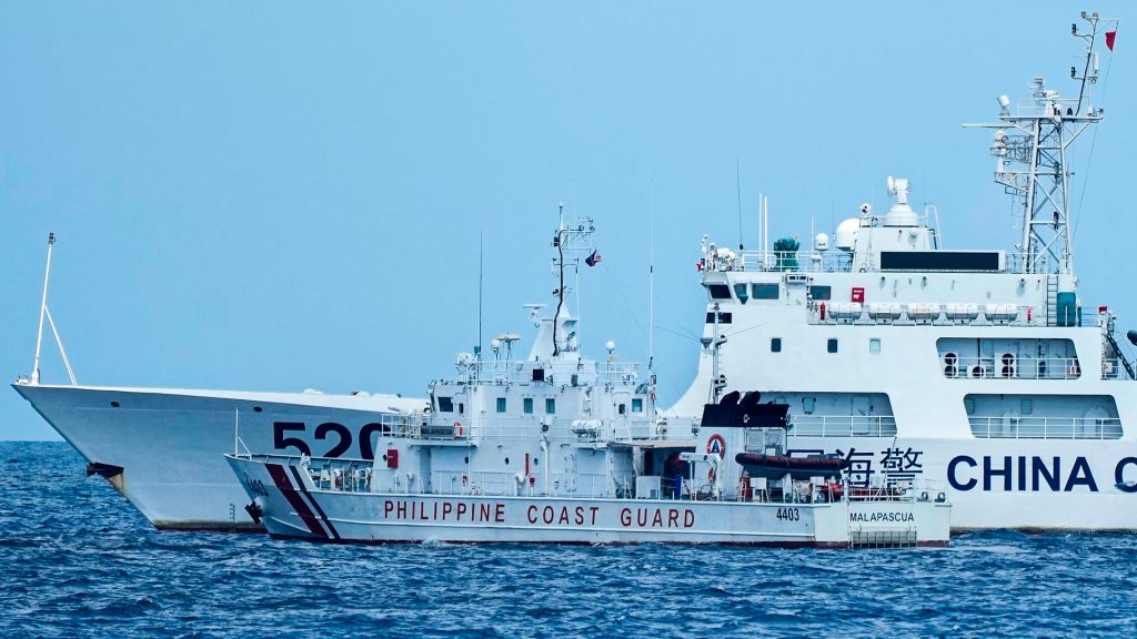 Buques de la Guardia Costera de China y Filipinas navegan próximos en el mar de la China Meridional, escenario de recurrentes disputas marítimas entre Beijing y Manila.
