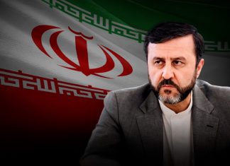 Irán: EE.UU. no podrá eludir sus responsabilidades al salirse del Consejo de Derechos Humanos El vicecanciller iraní Kazem Qaribabadi con bandera de Irán al fondo.