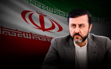 Irán: EE.UU. no podrá eludir sus responsabilidades al salirse del Consejo de Derechos Humanos El vicecanciller iraní Kazem Qaribabadi con bandera de Irán al fondo.
