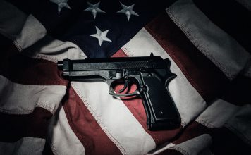El 71 % de las armas del crimen organizado en México proviene de EE.UU. Imagen ilustrativa que muestra Un arma automática sobre la bandera de Estados Unidos, en una imagen alusiva al flujo de armamento hacia México.