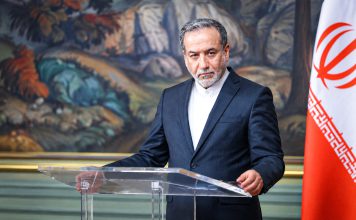 Araghchi “besaría la mano” de quien ejecute a Trump Funcionario iraní durante una comparecencia oficial junto a la bandera de Irán.
