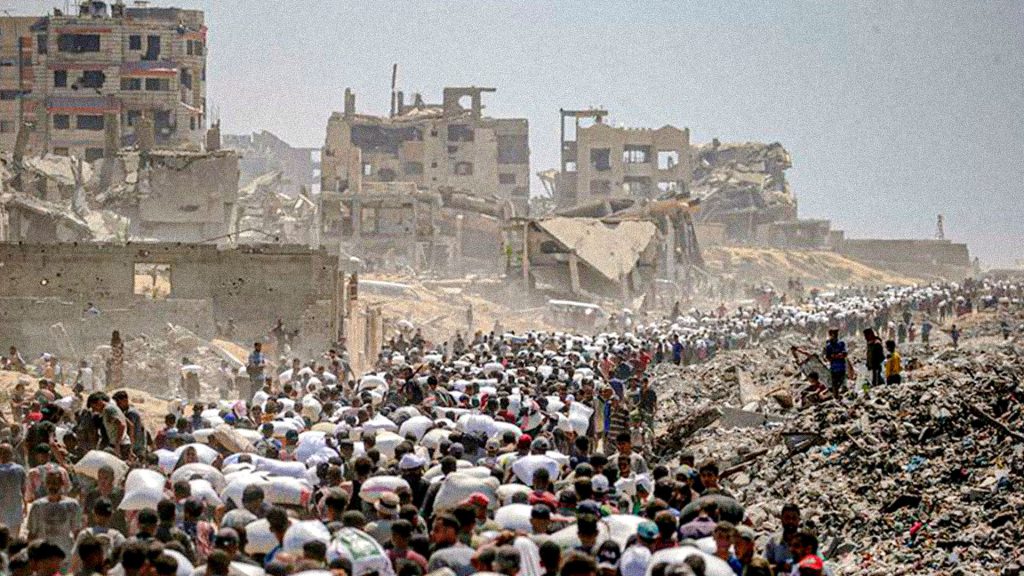 Palestinos desplazados caminan entre edificios destruidos en Gaza.