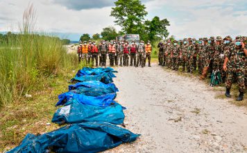 Nepal realiza entierros masivos de víctimas sin identificar Soldados permanecen junto a cuerpos cubiertos tras una inundación en Chitwan, Nepal.
