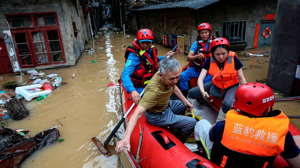 Rescatistas evacúan a un adulto mayor durante inundaciones en Fujian, China