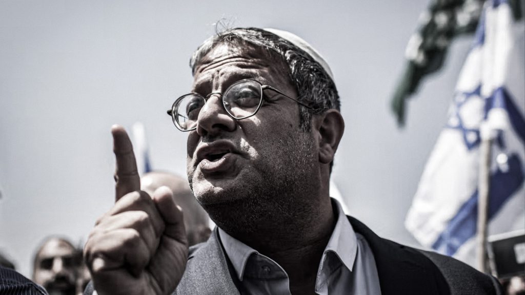 Itamar Ben-Gvir durante una intervención pública con una bandera de Israel al fondo.