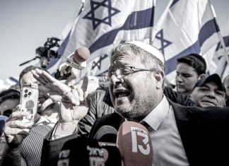 ¿Quién es Itamar Ben-Gvir? Ministro israelí durante un acto público frente a banderas de Israel.