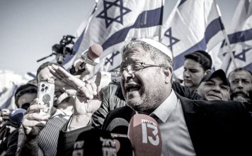 ¿Quién es Itamar Ben-Gvir? Ministro israelí durante un acto público frente a banderas de Israel.