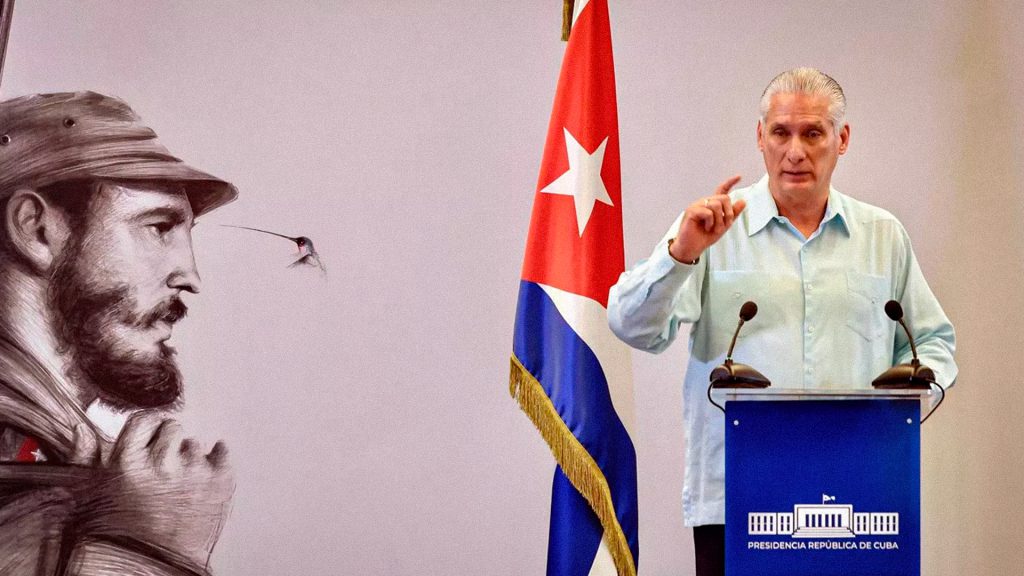 Presidente cubano durante un discurso frente a la bandera de Cuba.