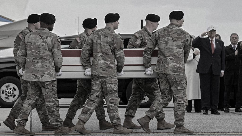 Militares estadounidenses trasladan un féretro cubierto con la bandera de Estados Unidos.