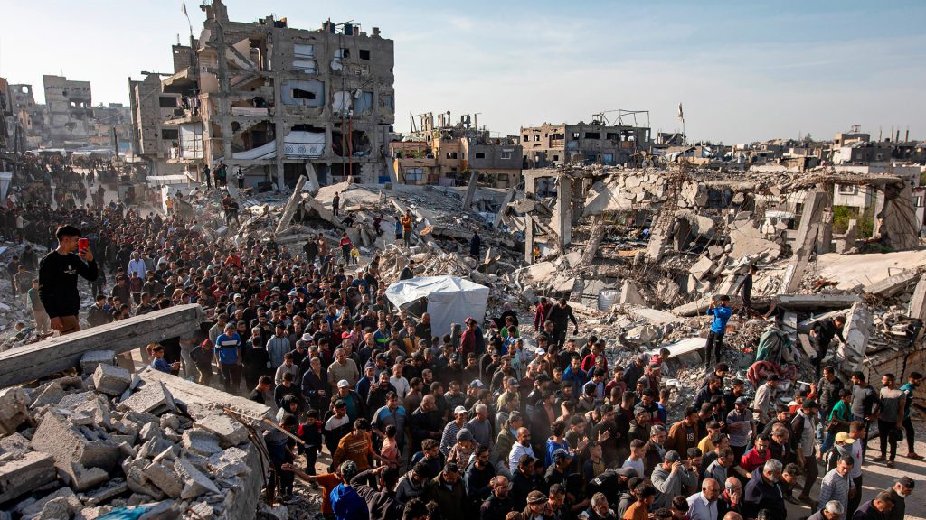 Palestinos entre edificios destruidos y escombros en Gaza