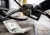 Irán a EEUU: Ustedes fueron quienes iniciaron esta guerra Manguera de gasolina junto a un billete de dólar que representa el costo del combustible.